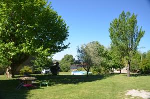 una mesa de picnic y sillas en un parque con árboles en Chez Germaine, en Les Granges-Gontardes