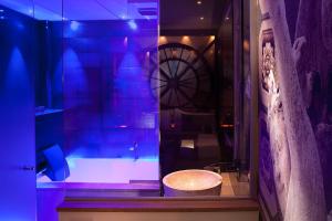 a bathroom with a tub and a clock in a room at Secret de Paris - Hotel & Spa in Paris