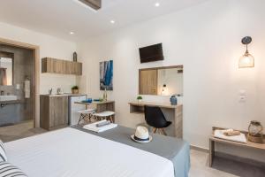 una camera con letto bianco e una cucina di Mikes Beach Lux a Hersonissos
