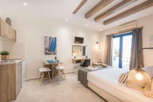 a bedroom with a bed and a desk and a kitchen at Mikes Beach Lux in Hersonissos