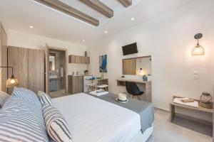 1 dormitorio con 1 cama blanca grande y escritorio en Mikes Beach Lux, en Hersonissos