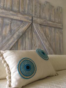 a pillow sitting on a bed with a wooden headboard at Cycladic House in Naousa