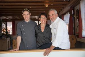 two men and a woman posing for a picture at Hotel Postigliun Andiast in Andest