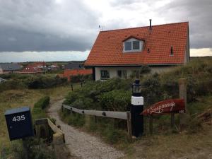 een huis met een vuurtoren aan de kant van een weg bij 't Zeepaardje in Midsland aan Zee