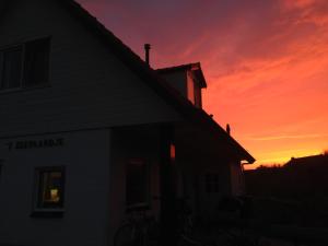 een huis met een zonsondergang op de achtergrond bij 't Zeepaardje in Midsland aan Zee