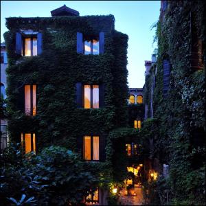 a tall building with ivy on it at night at Hotel Flora in Venice