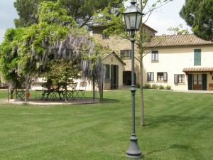 a lamp post in the grass in front of a house at Canto De' Bacci in Foiano della Chiana