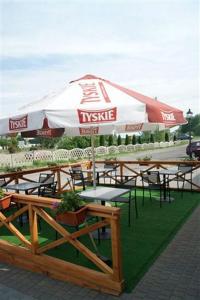 a group of tables with an umbrella on top of it at Pokoje Gościnne Gum-Bar in Biskupice