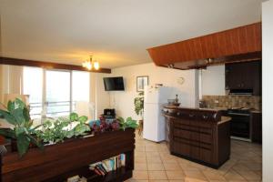 a kitchen with a white refrigerator and a kitchen with a counter at Macquarie Towers 17 1 Waugh Street in Port Macquarie