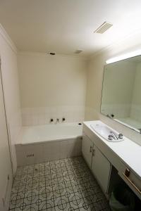 a bathroom with a tub and a sink and a mirror at Macquarie Towers 17 1 Waugh Street in Port Macquarie