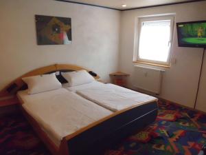 1 dormitorio con cama, ventana y TV en Smile Hotel, en Núremberg
