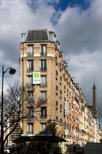 un edificio de ladrillo alto con un cartel. en Campanile Paris 15 - Tour Eiffel en París