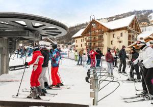 a group of people on skis on a ski lift at Résidence les chalets du Galibier Piscine Sauna Hammam WIFI in Valloire