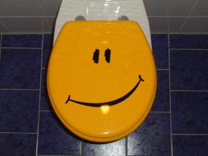 a yellow toilet with a smiley face drawn on it at Smile Hotel in Nuremberg