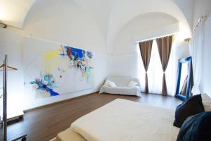 トラーパニにあるPaolo & Francesca's Trapani Loftのベッドルーム1室(ベッド1台付)が備わります。壁には絵画が飾られています。