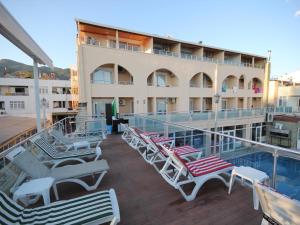 a balcony with lounge chairs and a swimming pool at Ucem Hotel Golden Sea in Altınoluk