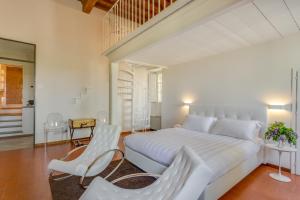 a hotel room with a bed and a chair at Villa I Barronci Resort & Spa in San Casciano in Val di Pesa