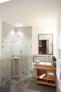 a bathroom with a glass shower and a sink at Hotel & Restaurant Wilder Mann in Aalen