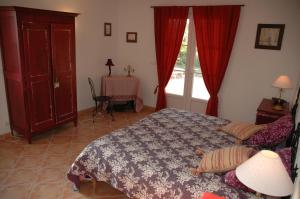 a bedroom with a bed and a table and a window at Gite de l'Amandari - classé 3 etoiles Prefecture - piscine chauffée privative, terrasses et jardin, 5 minutes à pied du village in Plan-de-la-Tour