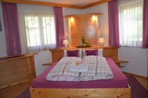 una camera da letto con un grande letto con lenzuola viola di Ferienwohnung Annemarie a Virgen