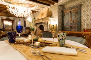 una mesa con mantel blanco y copas de vino en Relais Alberti en Lido de Venecia