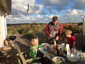 un hombre y dos niños sentados en una mesa en 't Zeepaardje en Midsland aan Zee