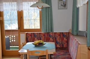 una sala de estar con una mesa con un bol de fruta. en Ferienwohnung Annemarie, en Virgen