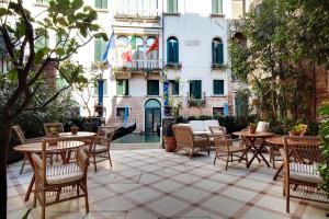 a patio area with tables, chairs and umbrellas at Hotel Donà Palace in Venice