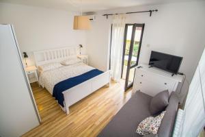 een slaapkamer met een bed, een tv en een bank bij Pineta House Vidos in Poreč