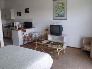 a room with a bed and a tv and a kitchen at Jamaed Court in George
