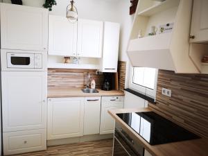 a white kitchen with white cabinets and a sink at Ferienappartement in St. Margarethen in Sankt Margarethen im Burgenland