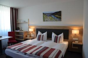 een hotelkamer met een groot bed met 2 kussens bij Flair Hotel am Rosenhügel - Garni in Cochem