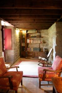 sala de estar con 2 sillas y estante para libros en Hotel O Portelo Rural, en Allariz