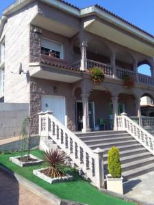 a large house with a staircase in front of it at piso chalet en playa samil in Vigo