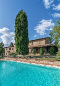 a large pool in front of a building with a tree at Tenuta San Vito In Fior Di Selva in Montelupo Fiorentino