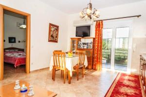 A television and/or entertainment centre at Cozy flats in an olive grove by the sandy beach