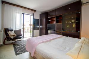 a bedroom with a bed and a chair and a television at Pineta House Vidos in Poreč