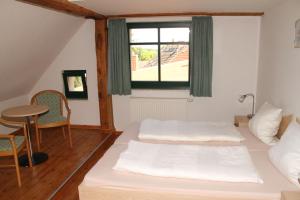 a bedroom with two beds and a table and a window at Landgasthof "Wirtshaus Zur Eibe" in Jabel