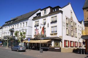 a white building on the corner of a street at Pension Post Rüdesheim in Rüdesheim am Rhein