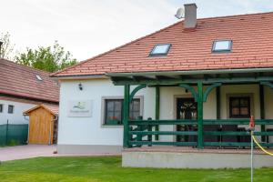 a house with a red roof with a green railing at Tündérgyöngye Apartmanház in Zirc