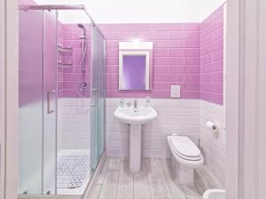 a purple bathroom with a sink and a toilet at B&B Rest a Napoli in Naples