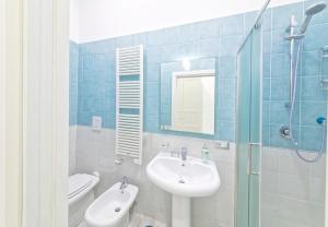 a bathroom with a sink and a toilet and a mirror at B&B Rest a Napoli in Naples