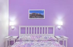 a bedroom with purple walls and a bed with two tables at B&B Rest a Napoli in Naples