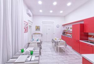 a kitchen with tables and chairs and red cabinets at B&B Rest a Napoli in Naples