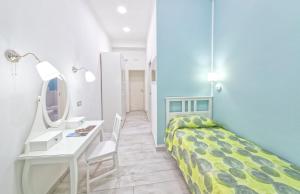 a bedroom with a bed and a desk and a mirror at B&B Rest a Napoli in Naples
