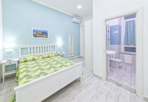 a white bedroom with a bed and a bathroom at B&B Rest a Napoli in Naples
