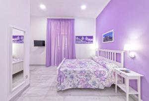 a purple bedroom with a bed and a table at B&B Rest a Napoli in Naples