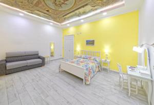 a bedroom with a bed and a couch and a table at B&B Rest a Napoli in Naples