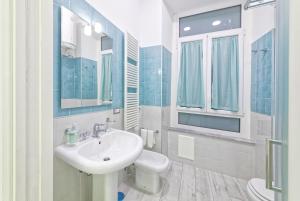 a blue and white bathroom with a sink and a toilet at B&B Rest a Napoli in Naples