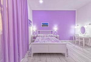 a purple bedroom with a bed and a table at B&B Rest a Napoli in Naples